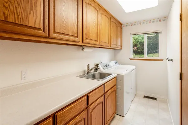 a utility room with sink dryer and washer