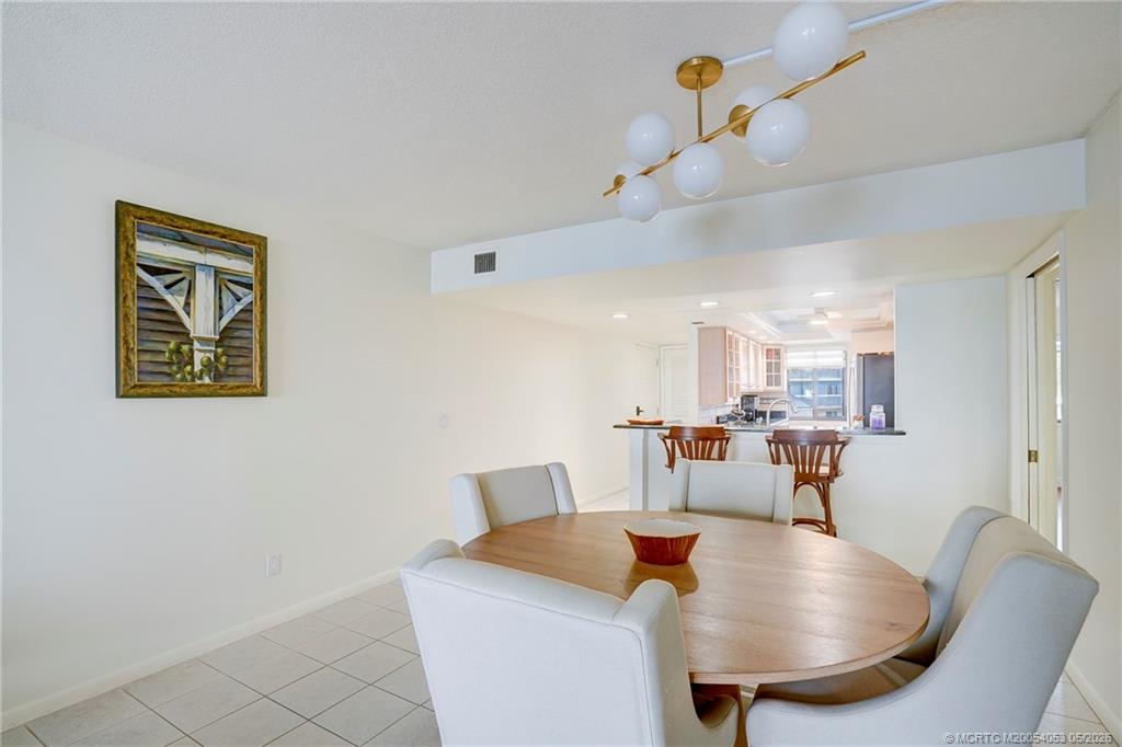 10 Northeast Plantation Road, Unit 101 Jensen Beach, FL 34957 - Photo 36 of 53 a living room with stainless steel appliances furniture a chandelier and kitchen view