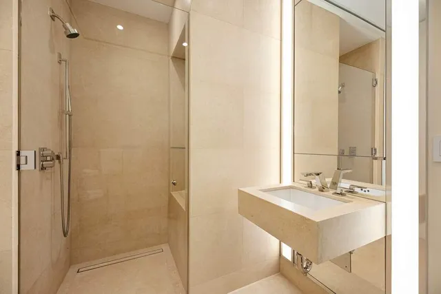 a bathroom with a sink shower and a mirror