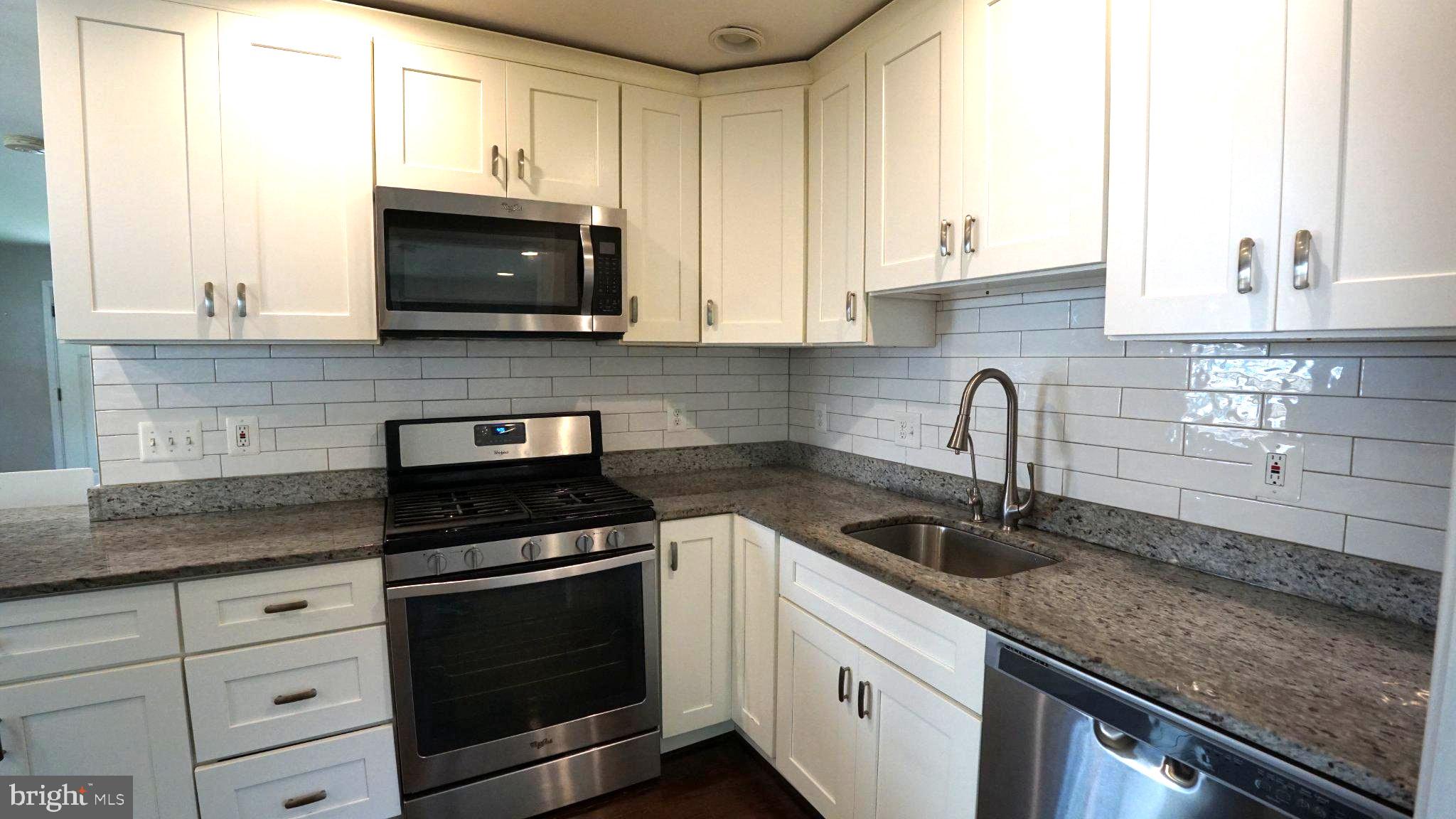 2006 Griffith Road Falls Church, VA 22043 - Photo 4 of 17 a kitchen with granite countertop white cabinets and black appliances