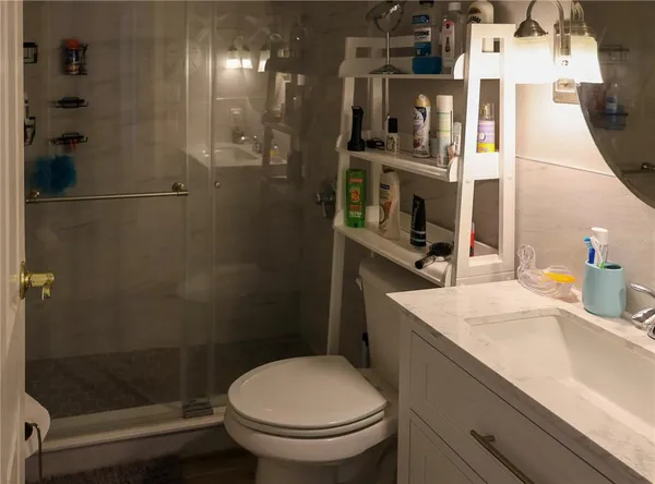 a bathroom with a sink a toilet and shower