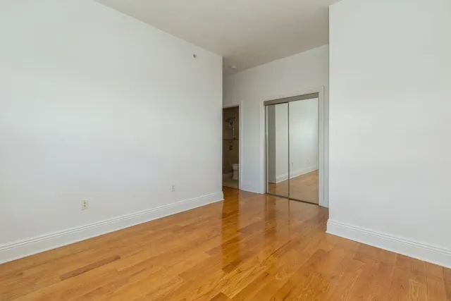 an empty room with wooden floor and closet