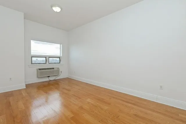 a view of a room with wooden floor and white walls