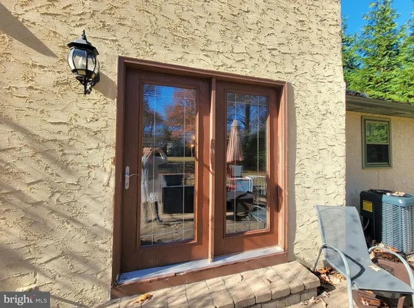 a view of a door and chair and fire pit in front of house