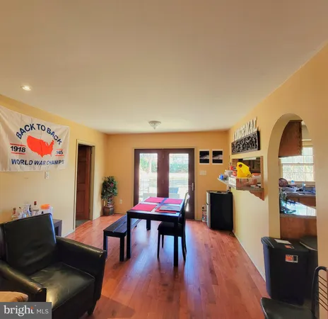 a living room with furniture and a dining table with wooden floor