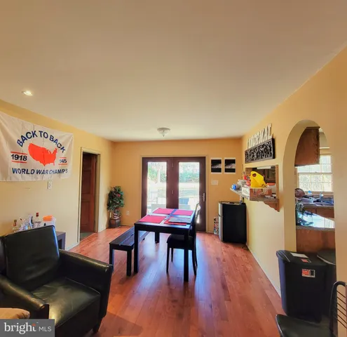 a living room with furniture and a dining table with wooden floor