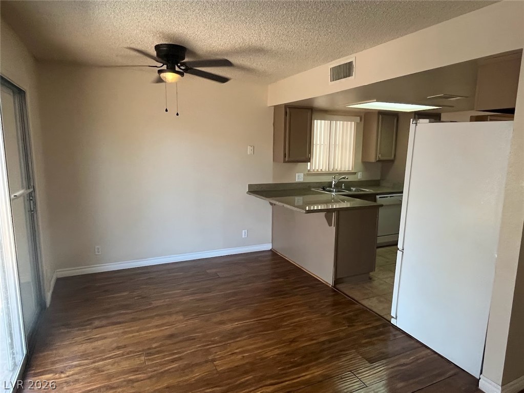 914 Scarlet Ridge Drive Las Vegas, NV 89128 - Photo 7 of 25 A versatile open-concept space featuring rich hardwood floors, an inviting kitchen bar, and convenient sliding glass doors.
