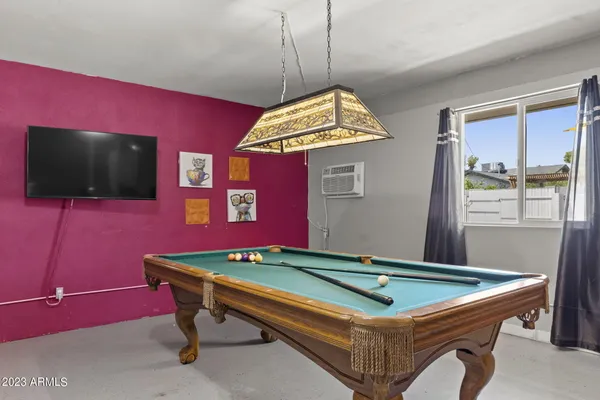 a room with pool table and windows
