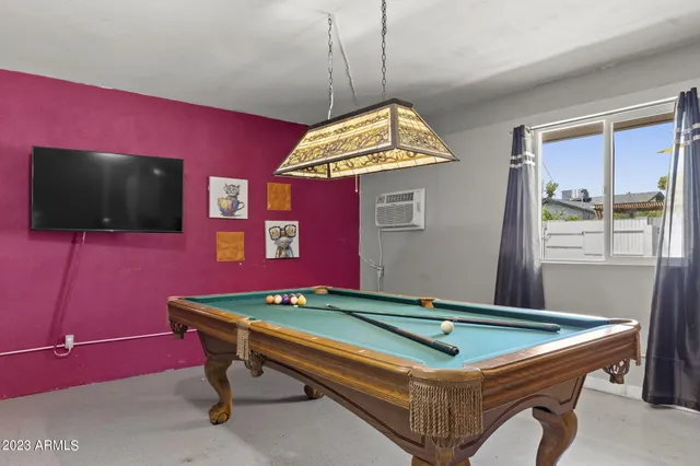 a room with pool table and windows