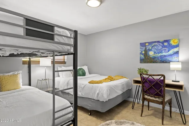 a bedroom with a bed and painting on the wall