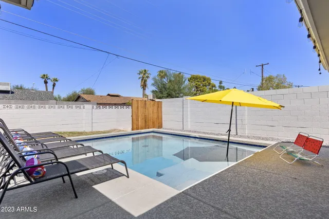 a view of a patio with table and chairs under an umbrella