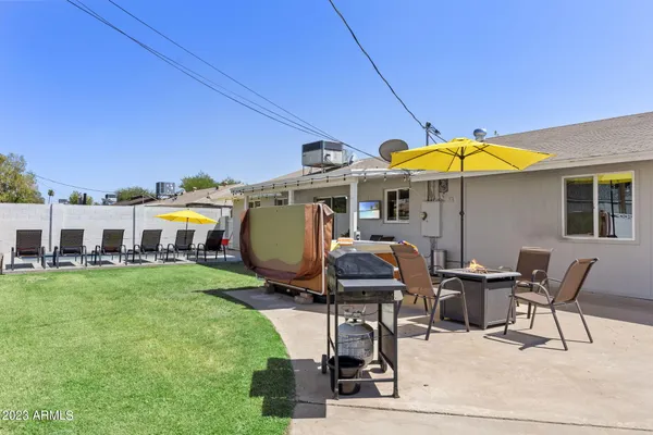 a view of a patio with table and chairs under an umbrella