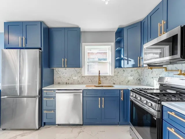 a kitchen with stainless steel appliances granite countertop a stove a refrigerator and a sink