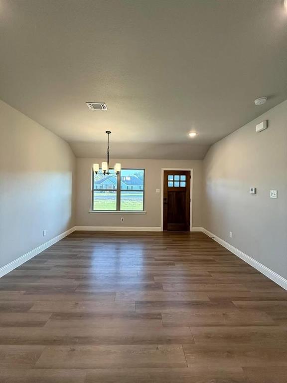 1015 Bluestem Weatherford, TX 76087 - Photo 2 of 11 a view of an empty room with window and wooden floor