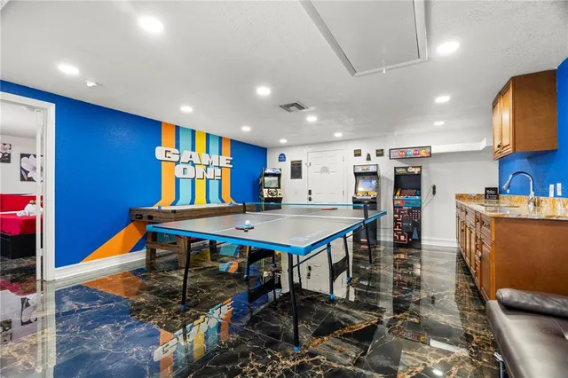 a room with furniture pool table table tennis and a rug