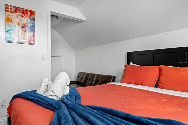 a bedroom with a bed and lamp on dresser