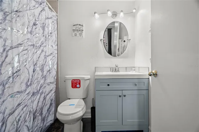 a bathroom with a toilet sink vanity and mirror
