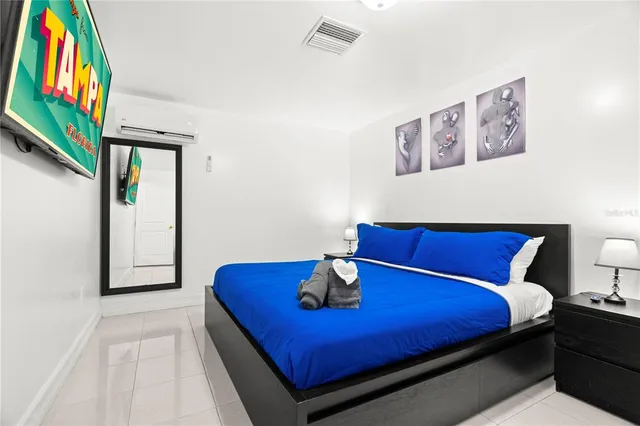 a bedroom with a bed and a painting on the wall