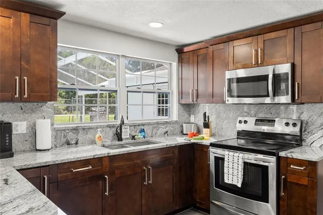 a kitchen with stainless steel appliances a stove sink microwave and cabinets