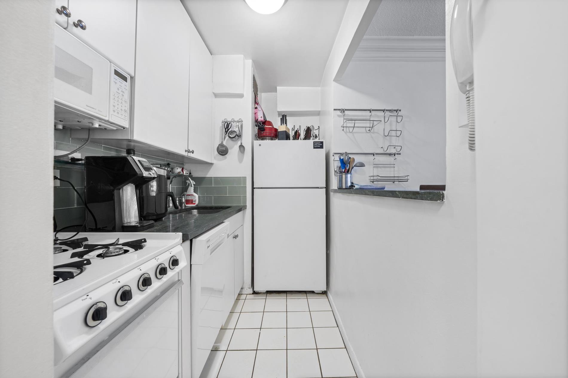 310 East 70th Street, Unit 1G Manhattan, NY 10021 - Photo 4 of 7 a kitchen with a refrigerator and a stove