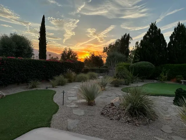 a backyard of a house with a garden and outdoor seating