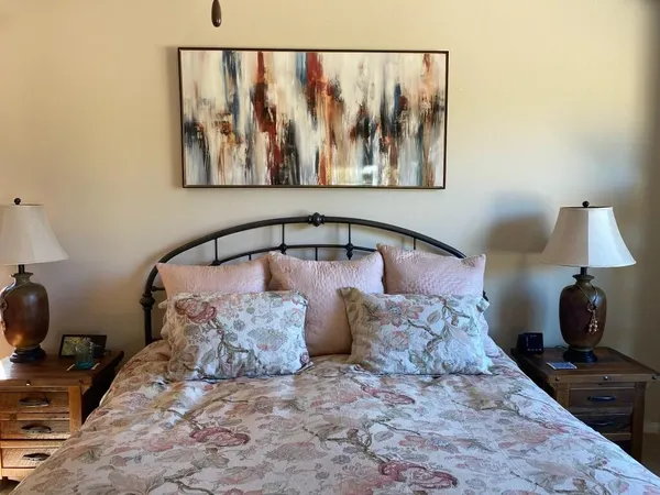 a bed room with a bed and a painting on the wall