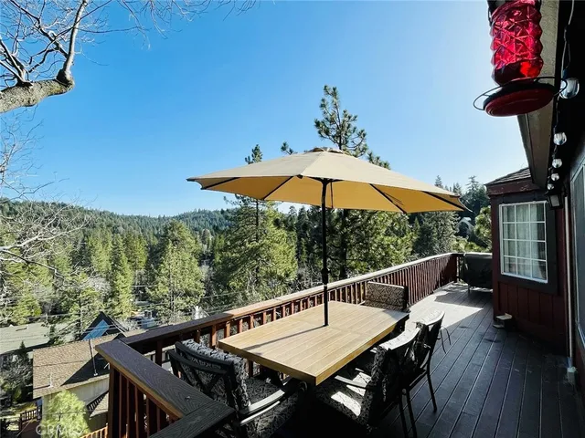 a view of deck with furniture and umbrella