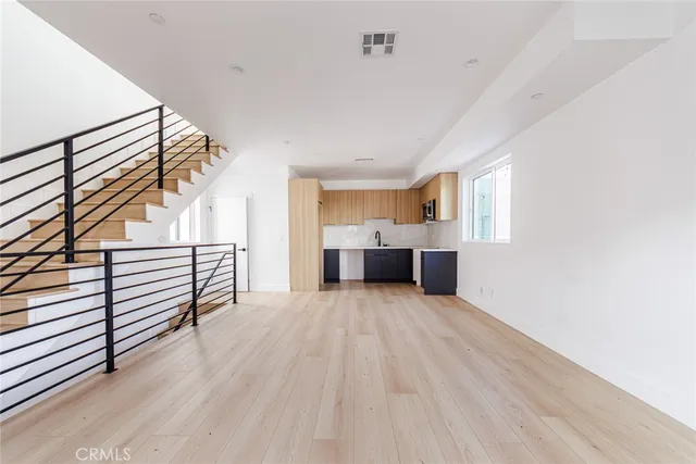 a view of empty room with wooden floor and windows