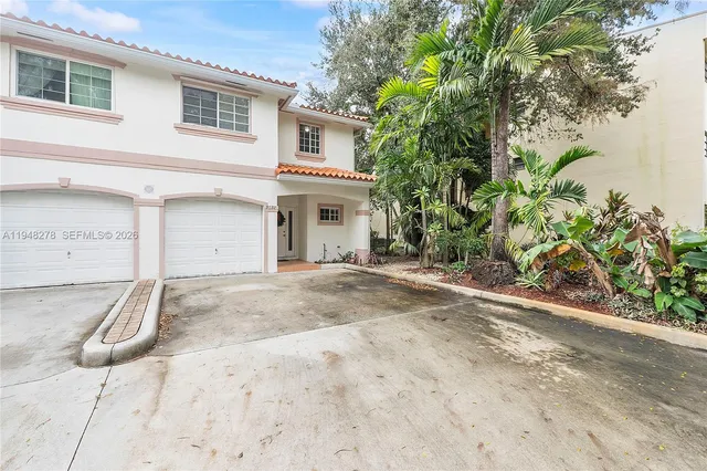 a view of a white house with a yard and a garage