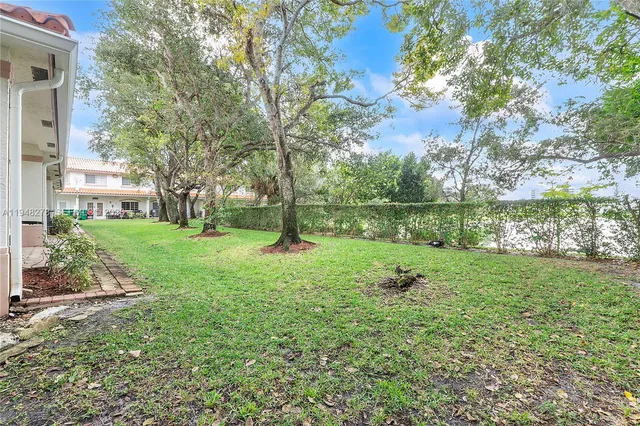 a view of a lake with a big yard and large trees