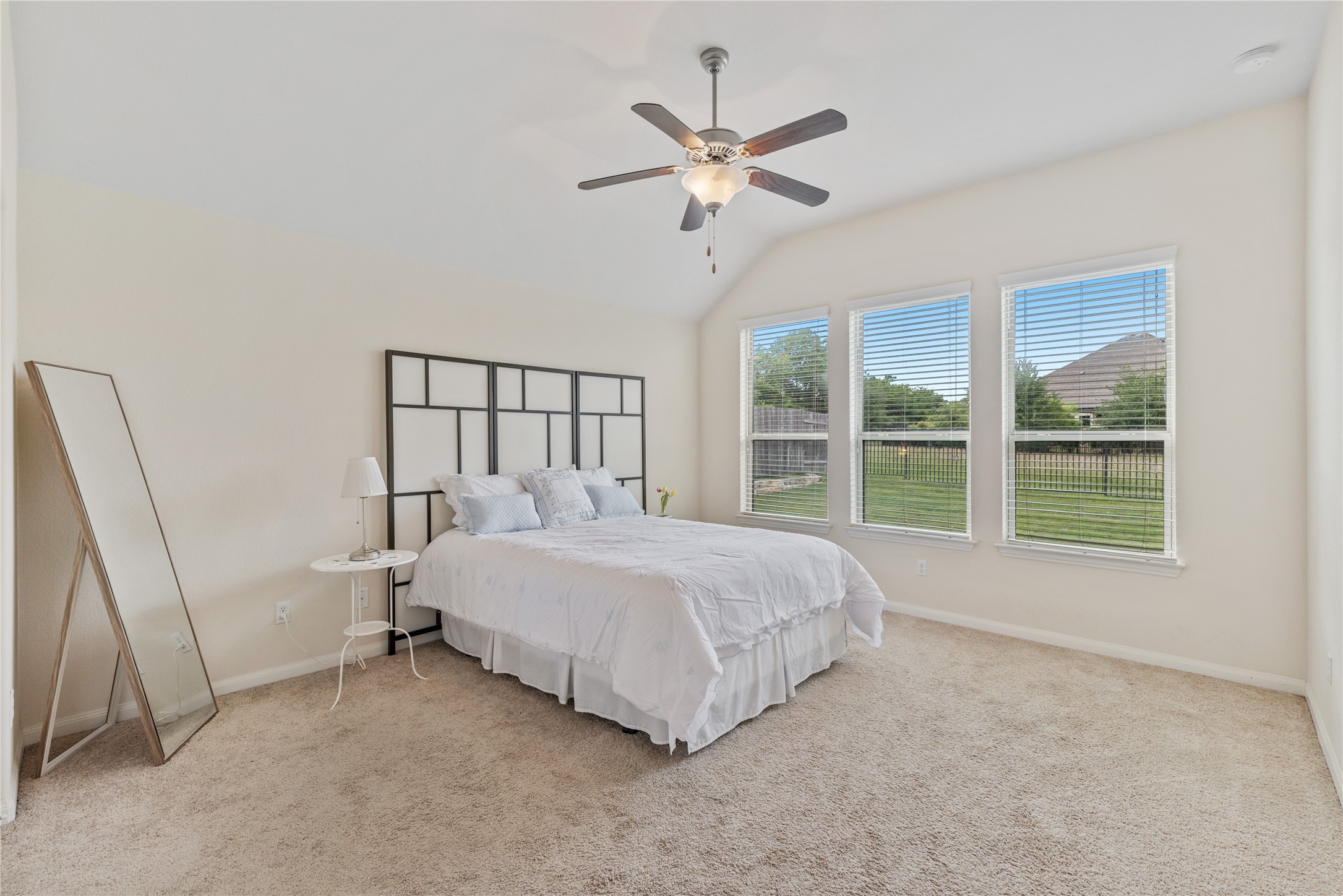 5012 Yucca Bloom Drive Georgetown, TX 78626 - Photo 11 of 35 Room featuring a vaulted ceiling with a ceiling fan, three windows with blinds, and neutral carpet flooring