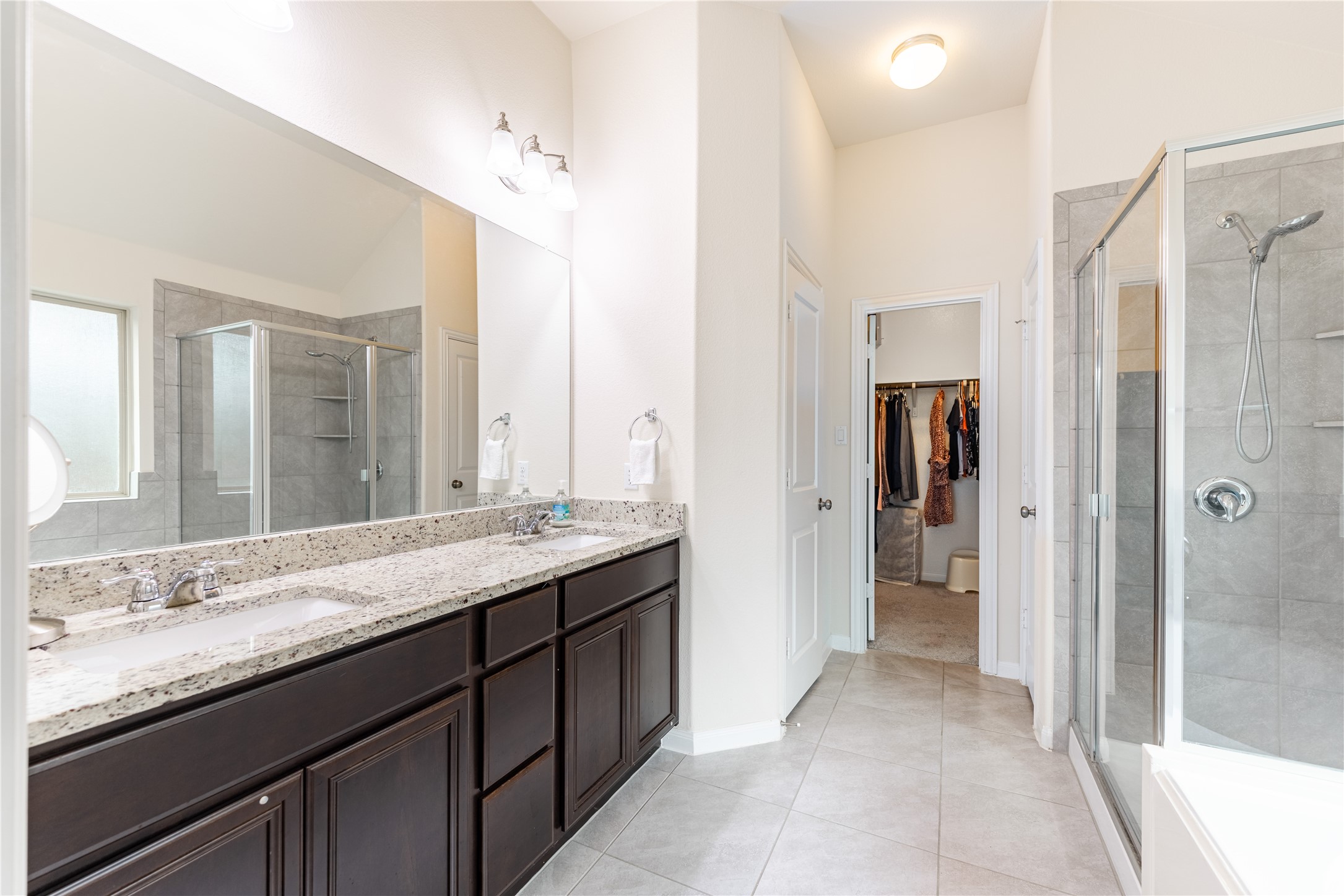 5012 Yucca Bloom Drive Georgetown, TX 78626 - Photo 12 of 35 Dual vanity with granite countertops, dark wood cabinetry, and chrome fixtures