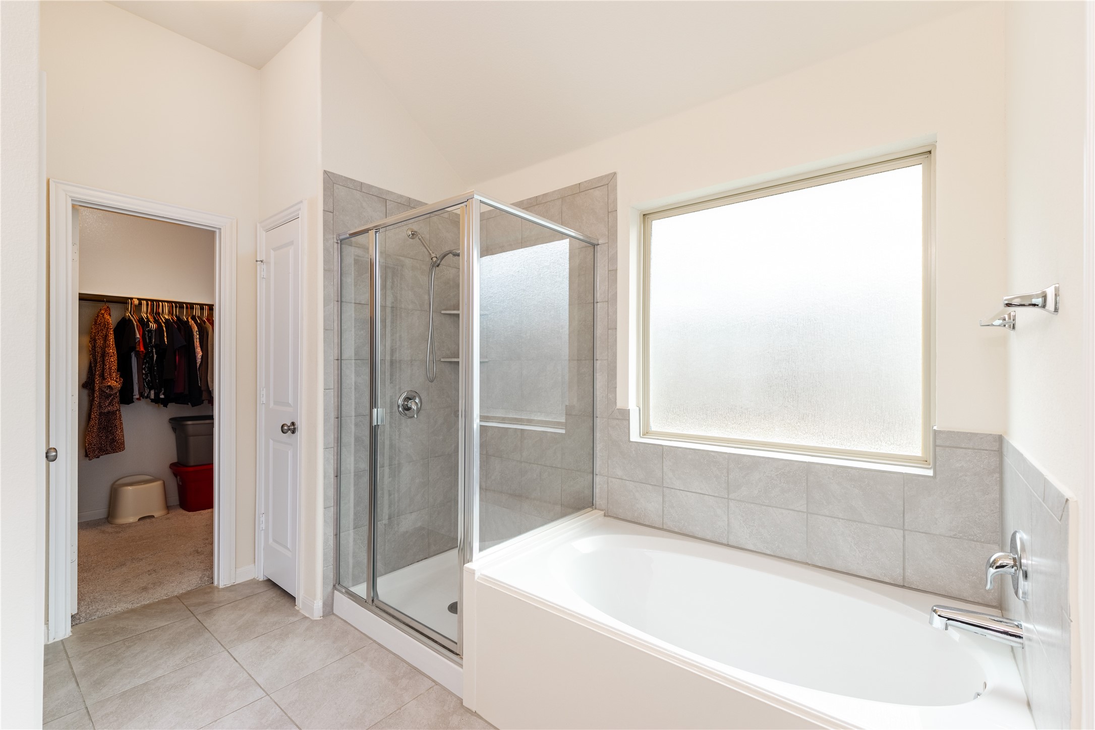 5012 Yucca Bloom Drive Georgetown, TX 78626 - Photo 13 of 35 Full bathroom featuring a glass-enclosed shower with tile surround, a soaking tub, and a frosted privacy window