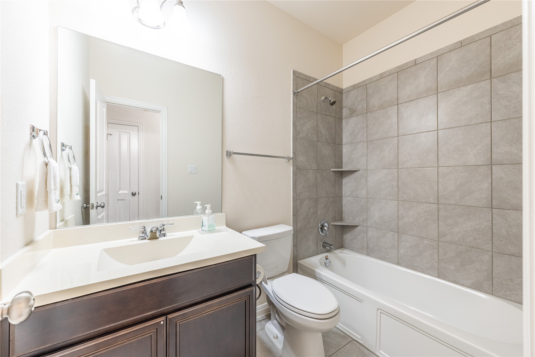 5012 Yucca Bloom Drive Georgetown, TX 78626 - Photo 22 of 35 Bathroom featuring a vanity with an integrated sink, dark wood-finish cabinetry, a large wall mirror, and overhead lighting
