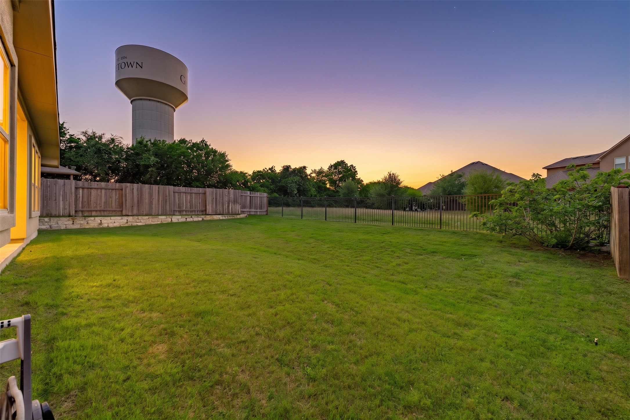 5012 Yucca Bloom Drive Georgetown, TX 78626 - Photo 26 of 35 Expansive green lawn with a perimeter wood fence and stone retaining wall