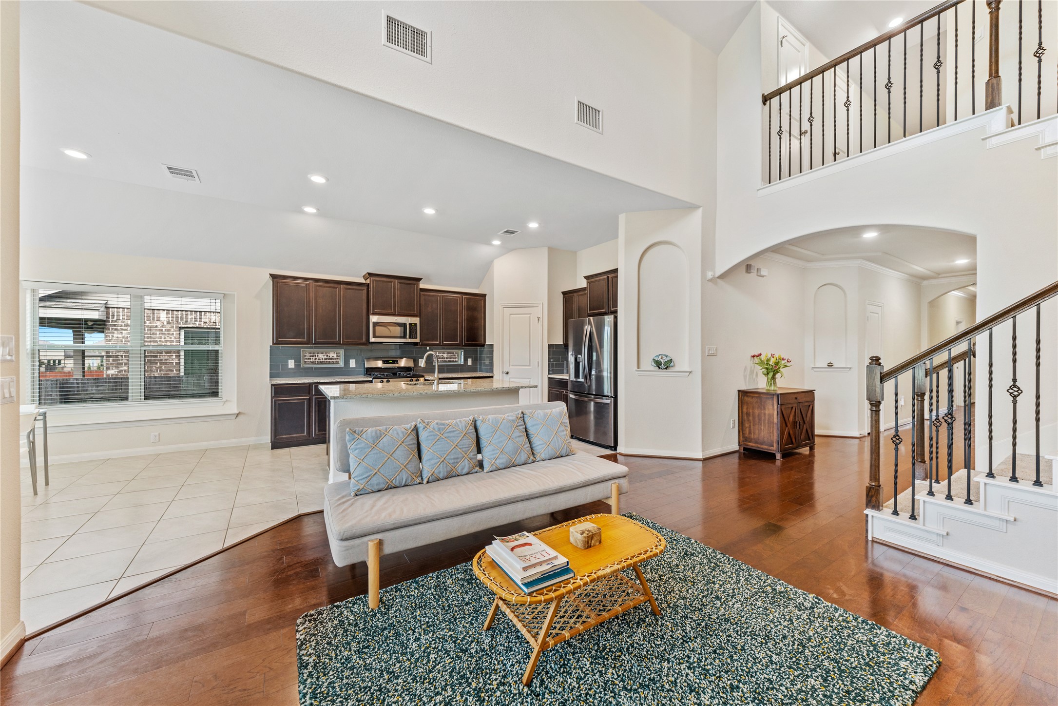 5012 Yucca Bloom Drive Georgetown, TX 78626 - Photo 5 of 35 Two-story living area with high ceilings, wood-finish flooring, and a wrought iron staircase