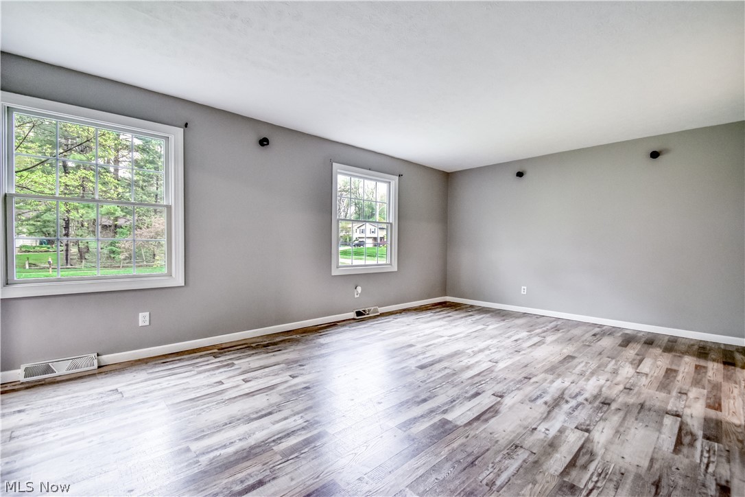 8242 Starburst Road Mentor, OH 44060 - Photo 31 of 37 Spacious room featuring light gray walls, wood-finish flooring, white baseboards, and two double-hung windows