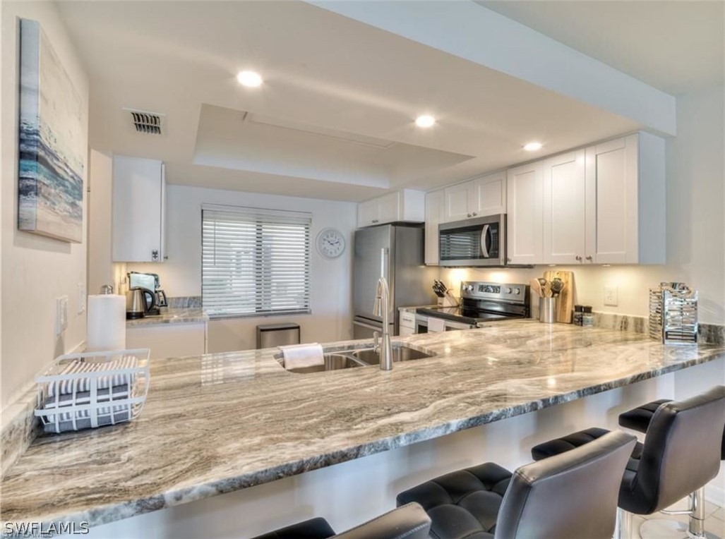 a large kitchen with stainless steel appliances lots of counter space and breakfast area