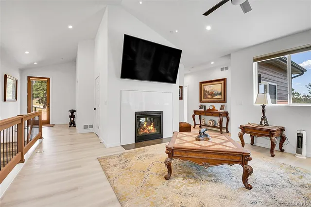 a living room with furniture a flat screen tv and a fireplace