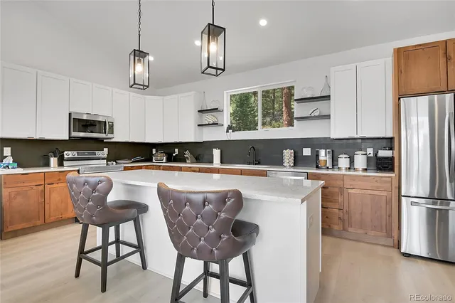 a kitchen with granite countertop a sink cabinets and stainless steel appliances