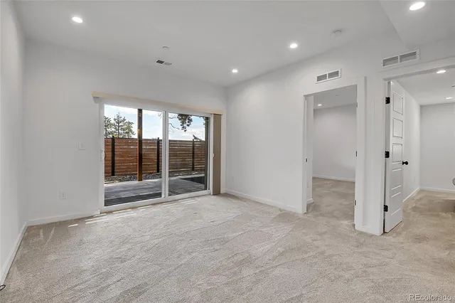 an empty room with large windows and a view of bedroom