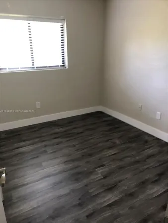 a view of a small space with wooden floor and a window