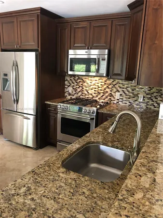 a kitchen with wooden cabinets and a stove top oven
