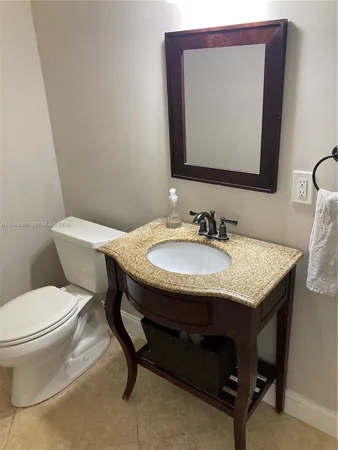 a bathroom with a toilet a sink and mirror