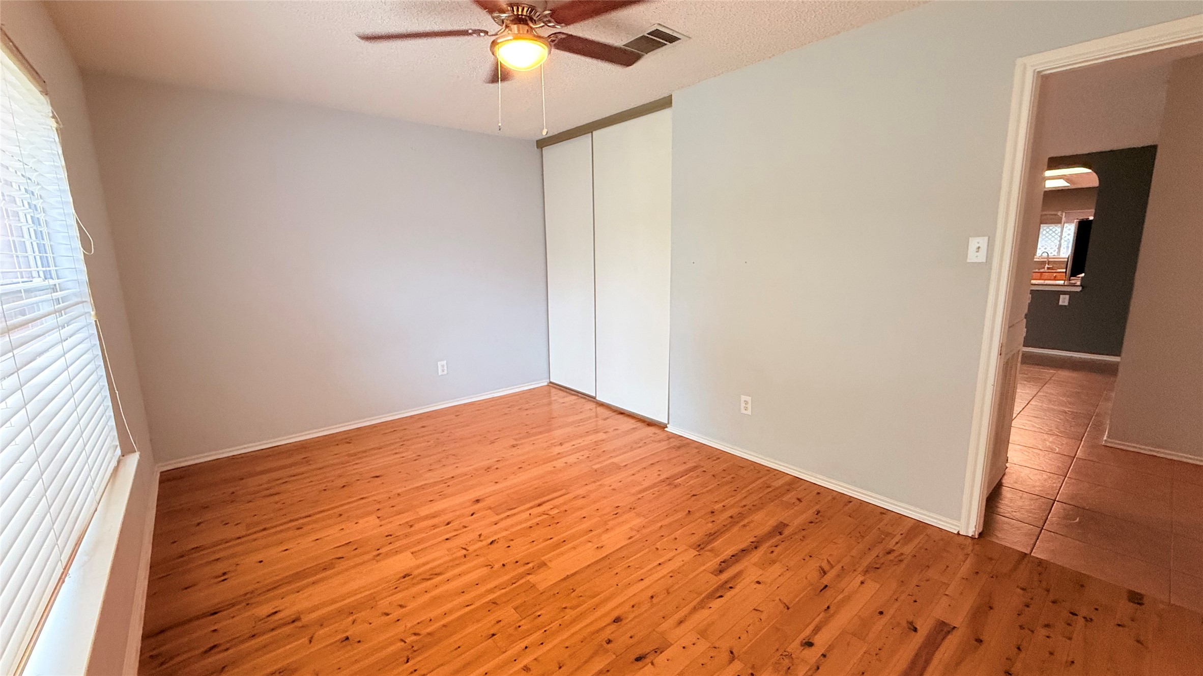 3324 Perch Trail Round Rock, TX 78665 - Photo 21 of 29 an empty room with wooden floor and way to kitchen