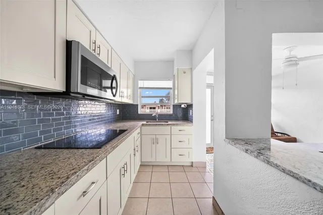 a kitchen with stainless steel appliances granite countertop a sink stove and microwave