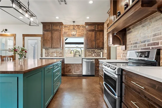 a kitchen with stainless steel appliances granite countertop a stove a sink and a refrigerator