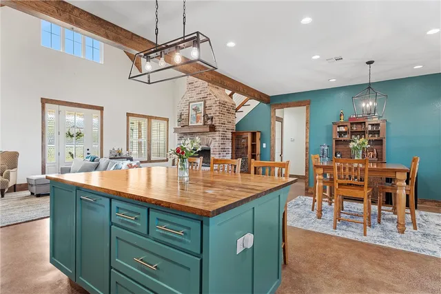 a dining hall with stainless steel appliances granite countertop a sink a counter top space and furniture