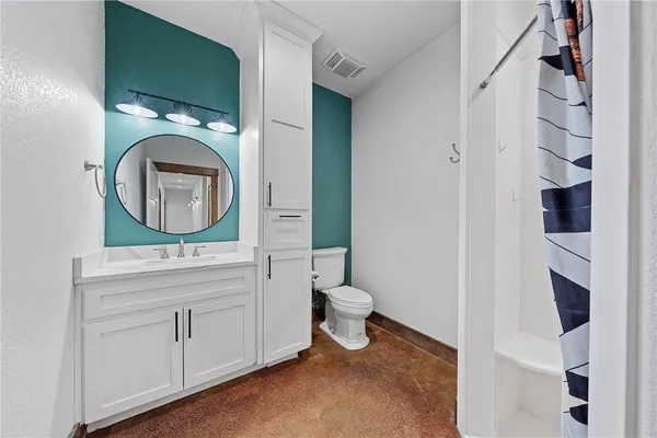 a bathroom with a toilet sink and mirror