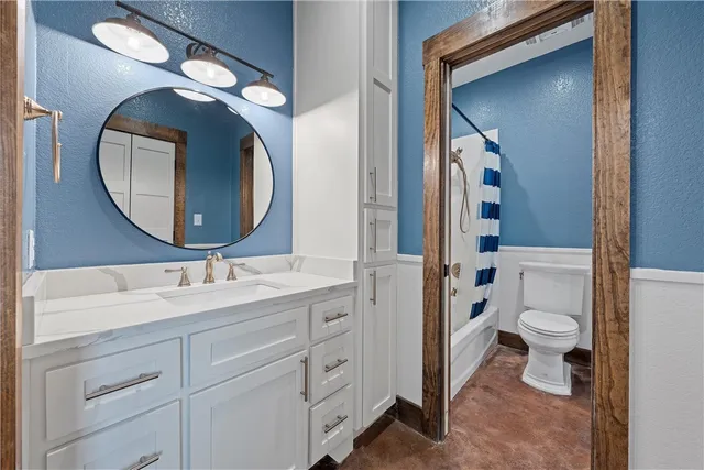 a bathroom with a toilet sink and mirror
